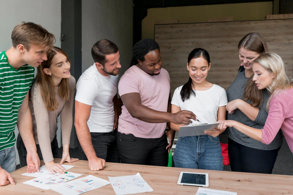 Group of happy people gathered around a tablet