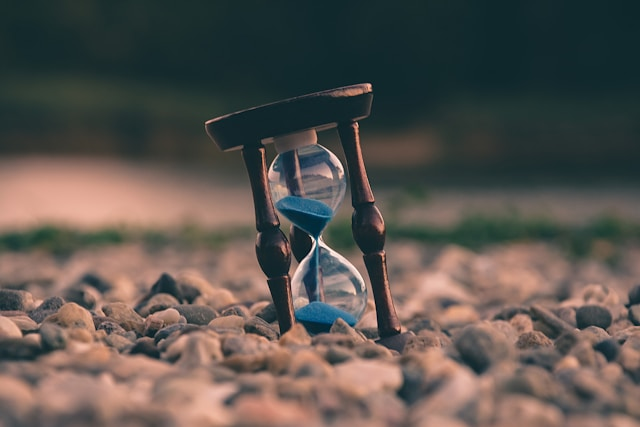 Sand hourglass timer among rocks