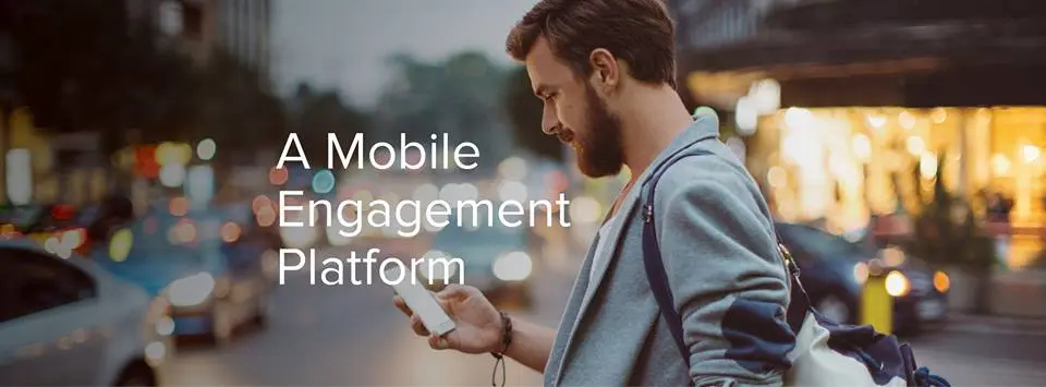 A mobile engagement platform text, with a man checking his phone