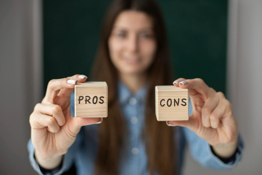 Woman holding wooden blocks with the words Pros and Cons written on them