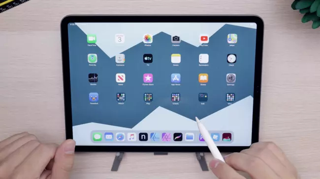 An iPad and 2 hands with an iPad pen