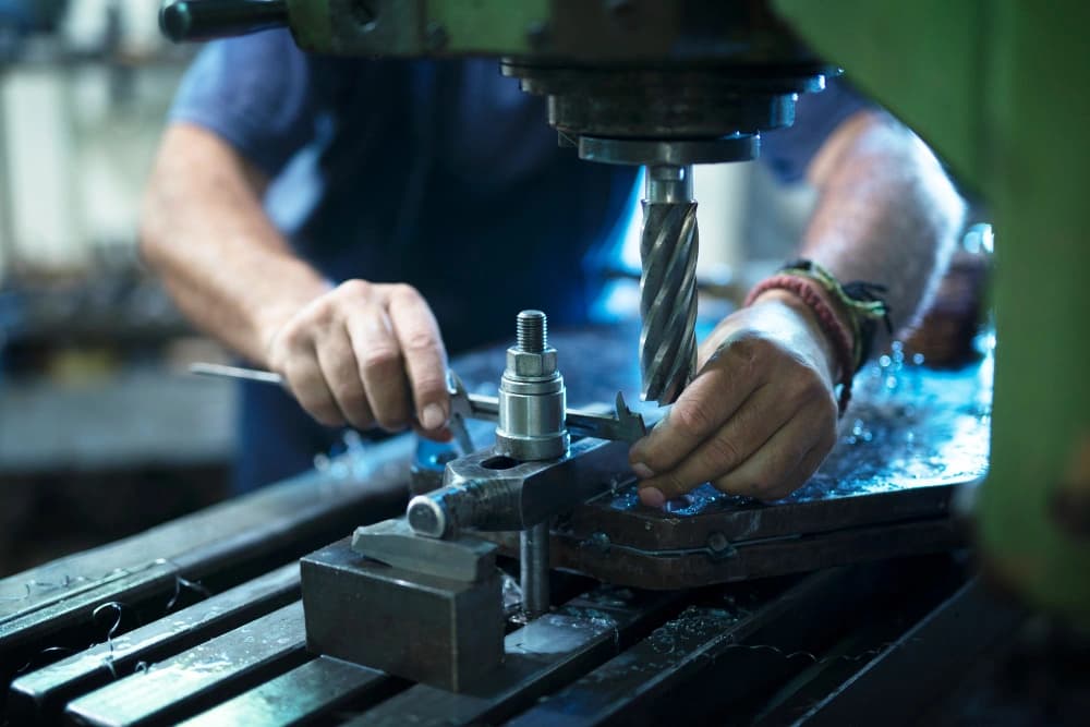 worker operating industrial machine in metal workshop